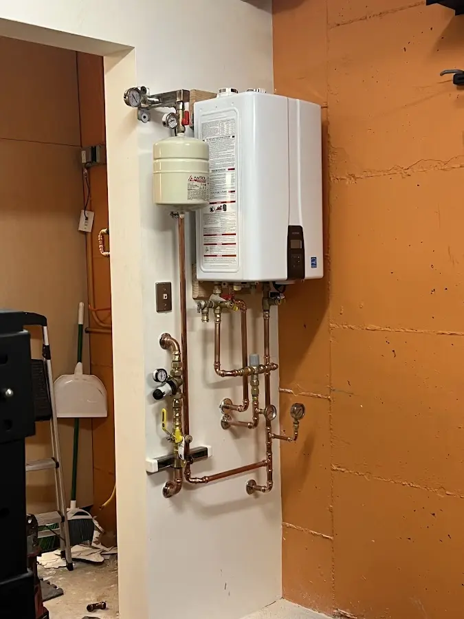 Plumbing technician inspecting water heater connections in Sunbury